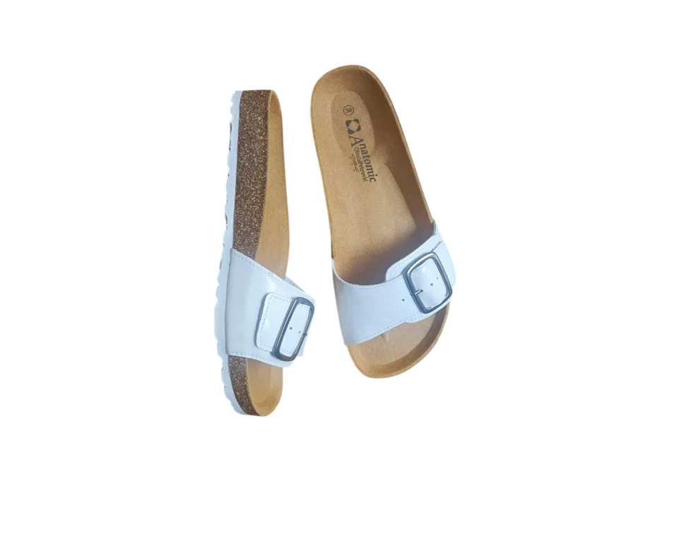 Ženske bijele lakirane papuče s plutenim đonom naslagane jedna na drugu, prikaz teksture lakirane kože. (2)